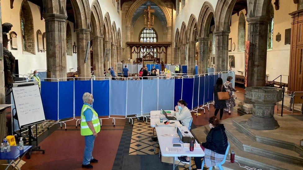 People attend their vaccination appointments inside the cathedral