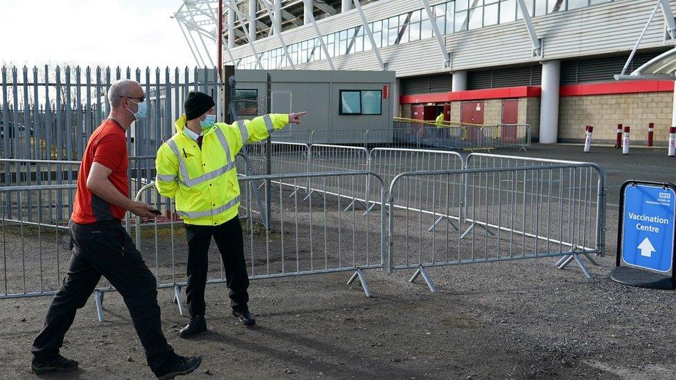 Man walks into Riverside Stadium which is a vaccine centre