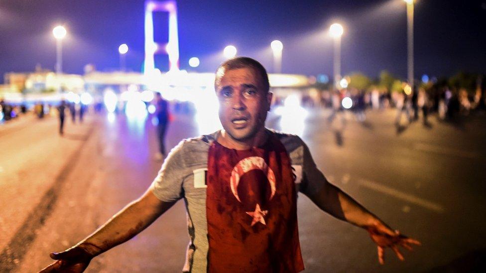 A man with a bloodied flag