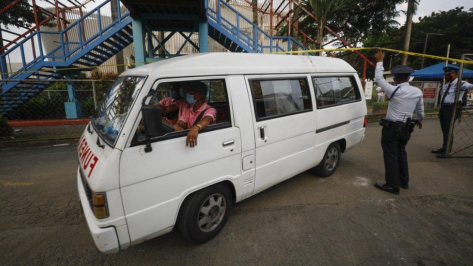 Funeral workers transport the body of a shooting victim at a university in Quezon City, Metro Manila, Philippines, 24 July 2022.