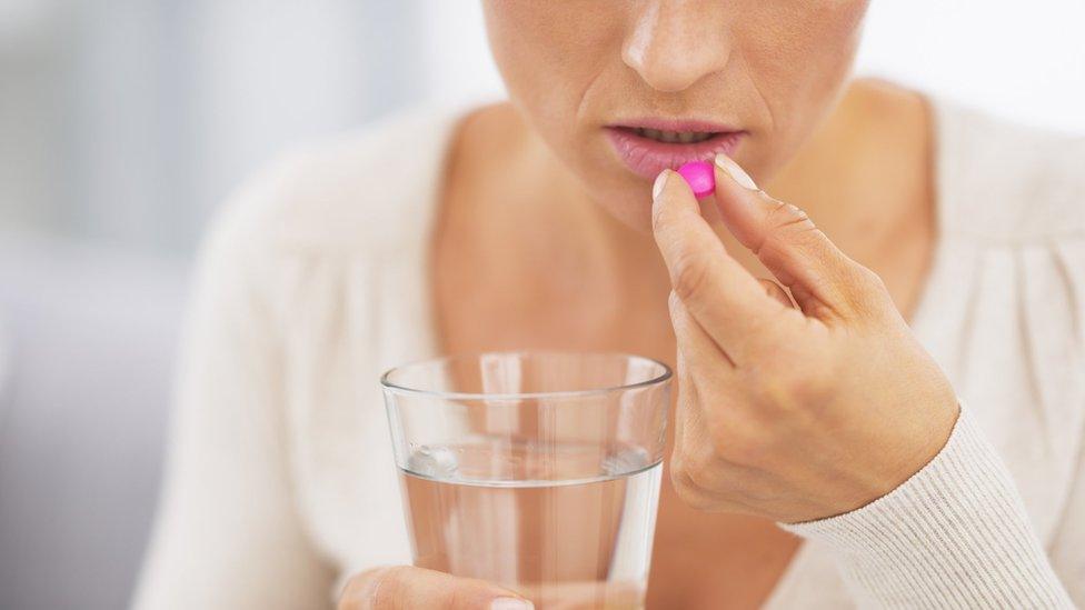 A woman taking a pill