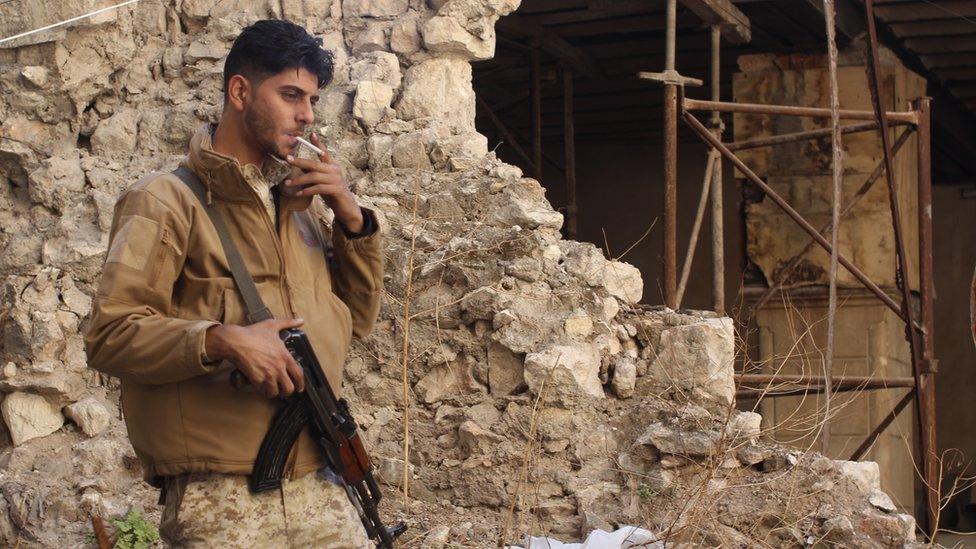 A soldier leaning against a damaged wall having a smoke, 3 November 2016
