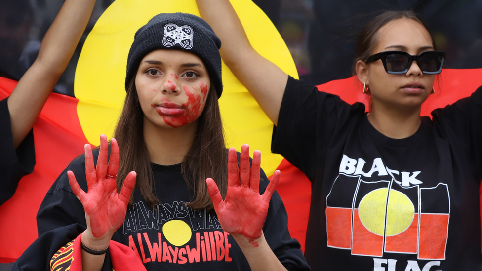 Protesters with red paint on their hands at a rally against black deaths in custody