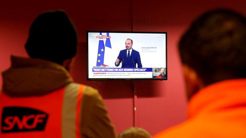 French SNCF railway workers on strike watch French Prime Minister Edouard Philippe deliver a speech on the government's pensions reform plans, at Strasbourg railway station, France