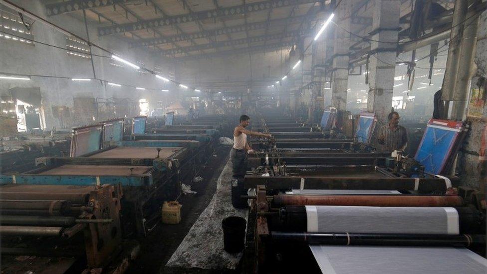 Employees work inside a sari, a traditional clothing worn by women, manufacturing factory in Surat, India, March 8, 2019