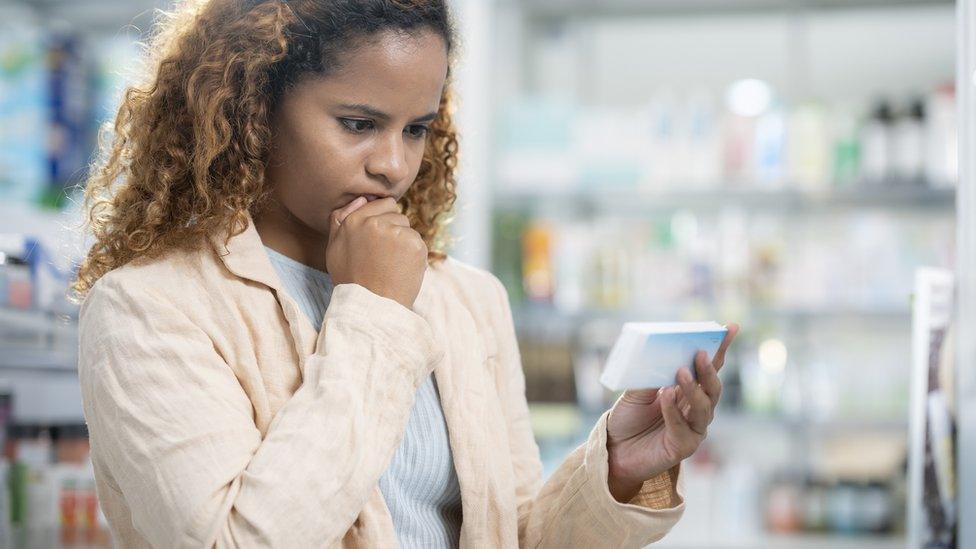 woman buying pills at a pharmacy