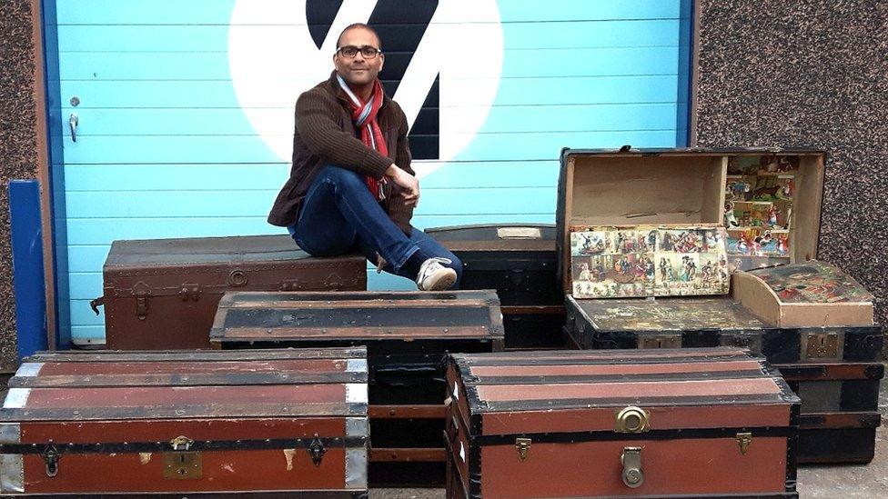 Shopowner, Carl, sitting on top of prop travel trunks