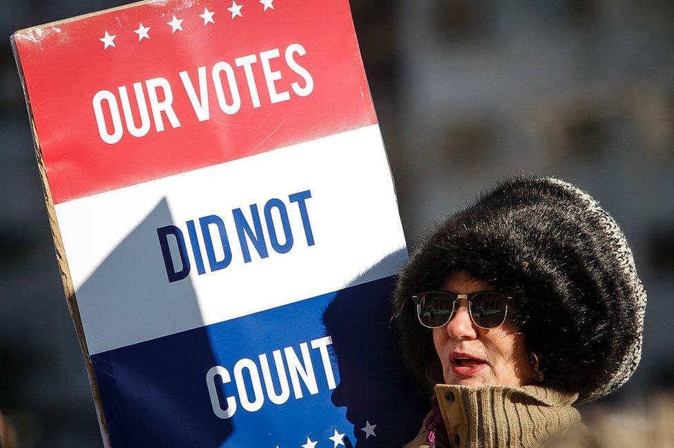 A protester outside the Michigan state capitol condemns the electors voting inside on Monday.