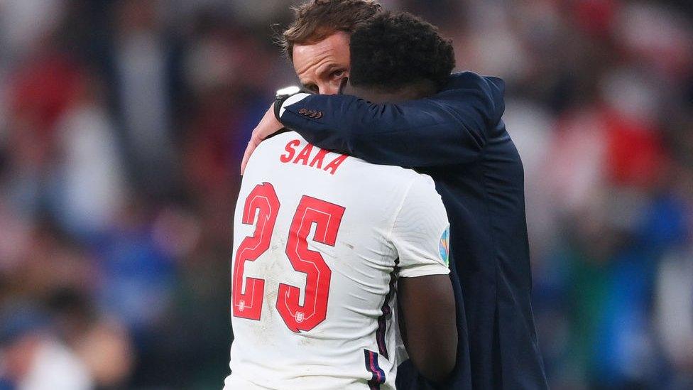 Southgate hugs Bukayo Saka.