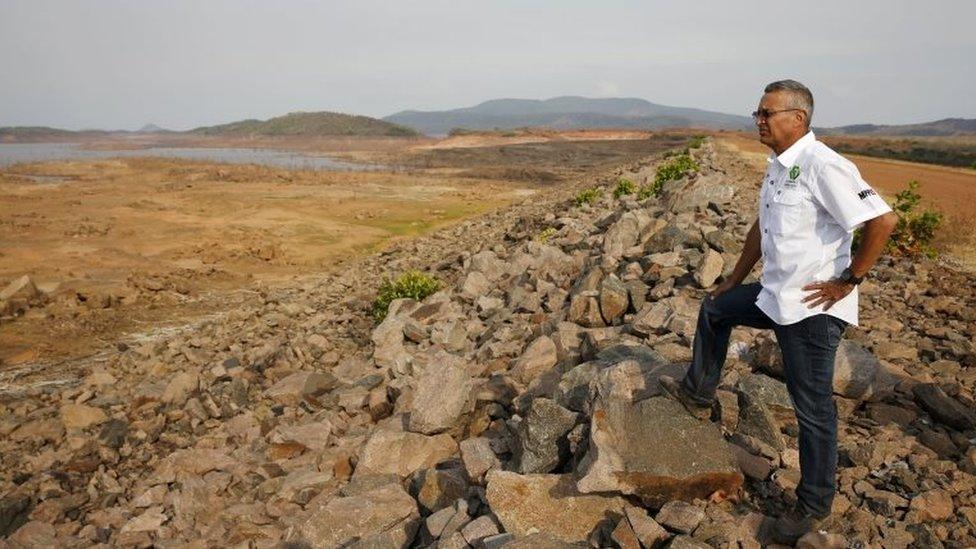 Electricity Minister Luis Motta looks at previously submerged land during an inspection at the Guri Dam in Bolivar state, Venezuela April 11, 2016