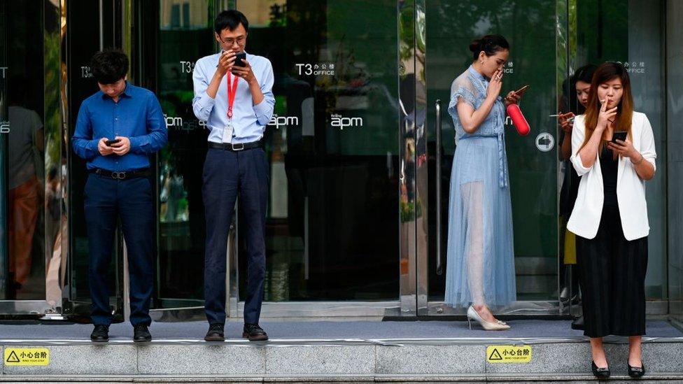 People smoking outside a shopping centre in Beijing