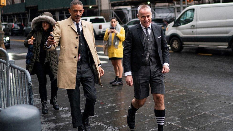 Thom Browne wears a sock bearing his four-stripe design