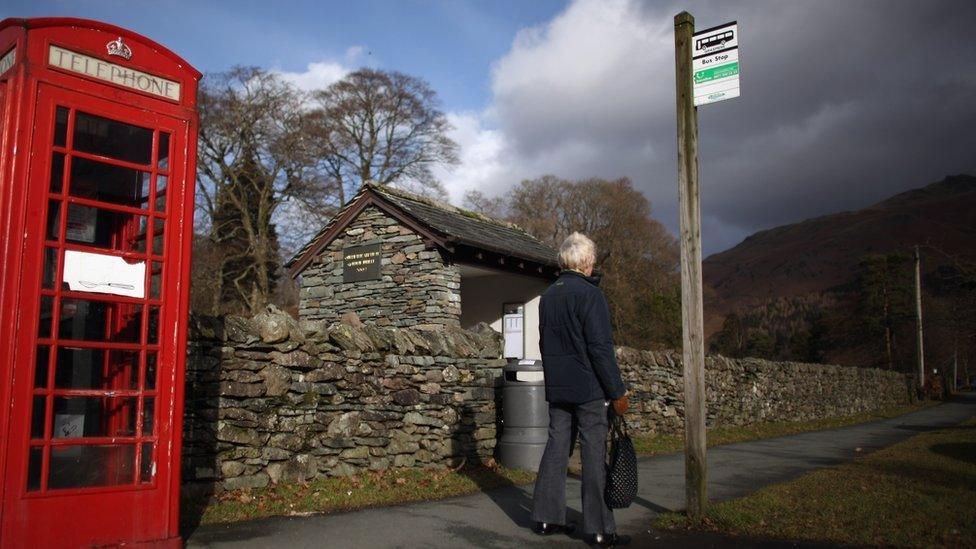 Woman waits at a rural bus stop