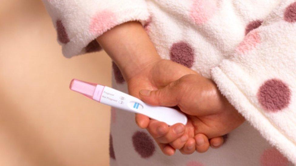 A woman holding a pregnancy test