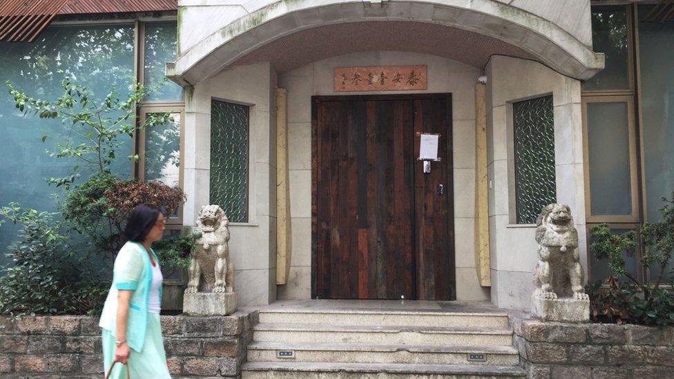 People walk past the closed Taian Table restaurant in Shanghai