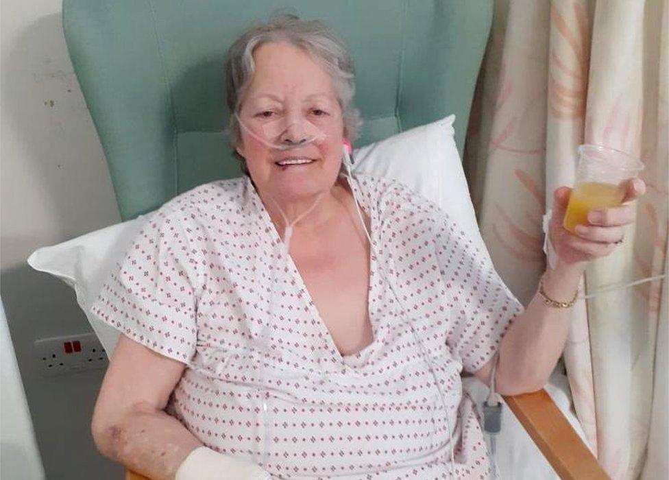 Mary Blessington drinking orange juice in hospital