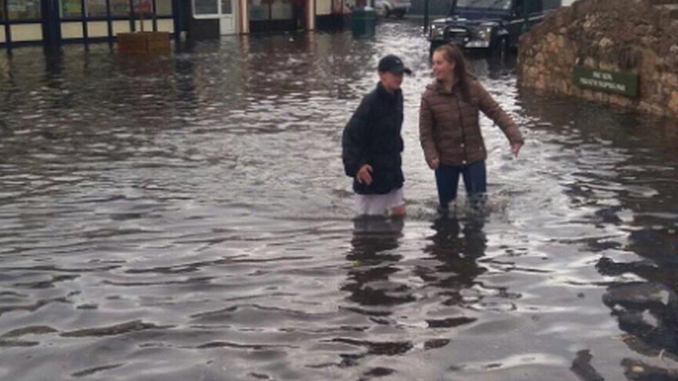 People wading through water on the flooded high street in Prestatyn