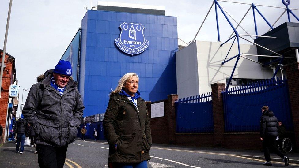 Fans walk past Goodison Park