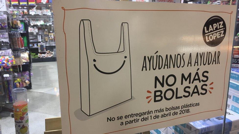 A sign reads "Help us help: No more bags. No more plastic bags will be handed out from 1 April 2018 "