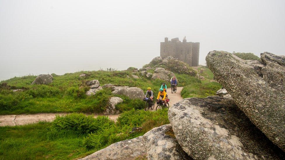 Cyclists riding by an abandoned fortification