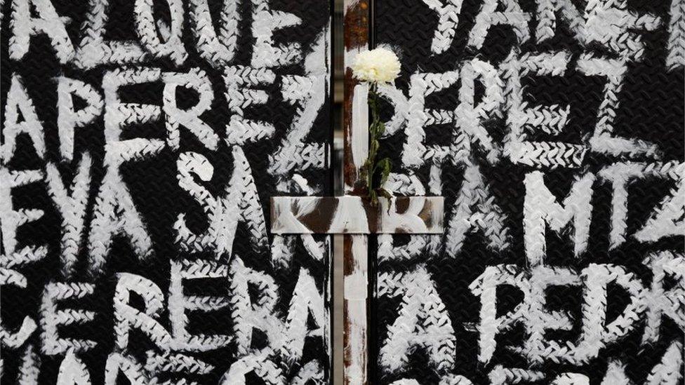 A flower is seen among the names of victims of femicide in Mexico painted by women on fences placed outside the National Palace ahead of a Women"s Day protest in Mexico City, Mexico March 7, 2021