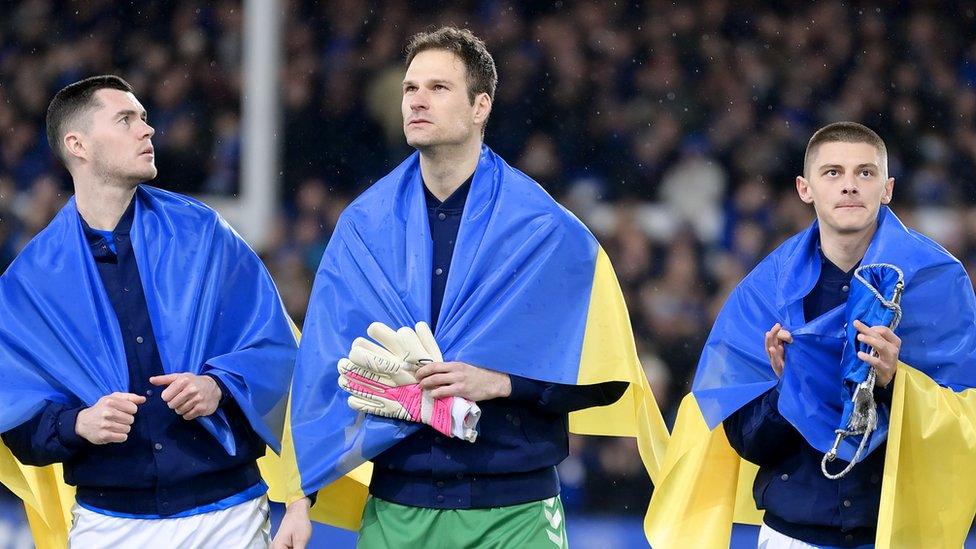 Michael Keane, Asmir Begovic and Vitaliy Mykolenko draped in Ukraine flags before the FA Cup match between Everton and Boreham Wood