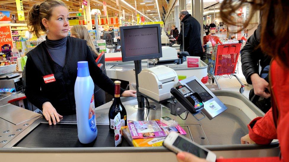 Shopper paying by smartphone in Auchan