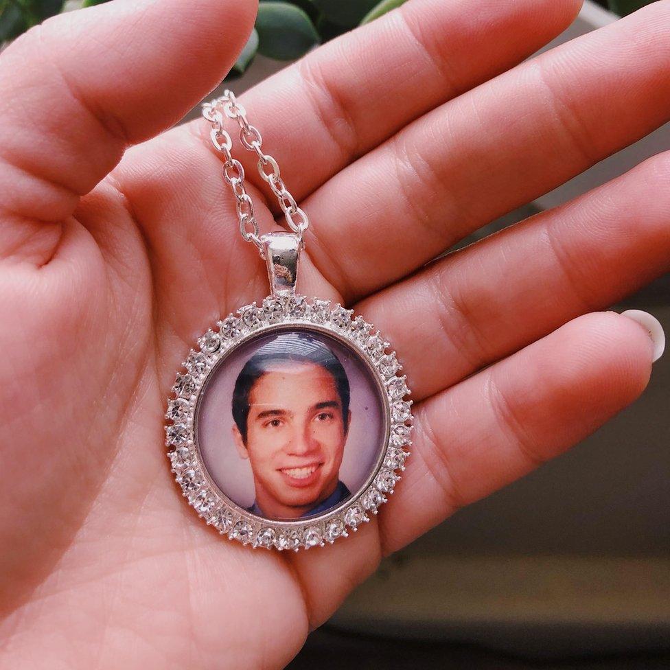 A pendant with a picture of Greg