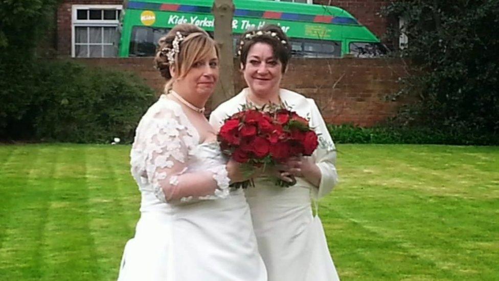 Jayne and Julie Taylor-Broadbent standing together in their wedding dresses