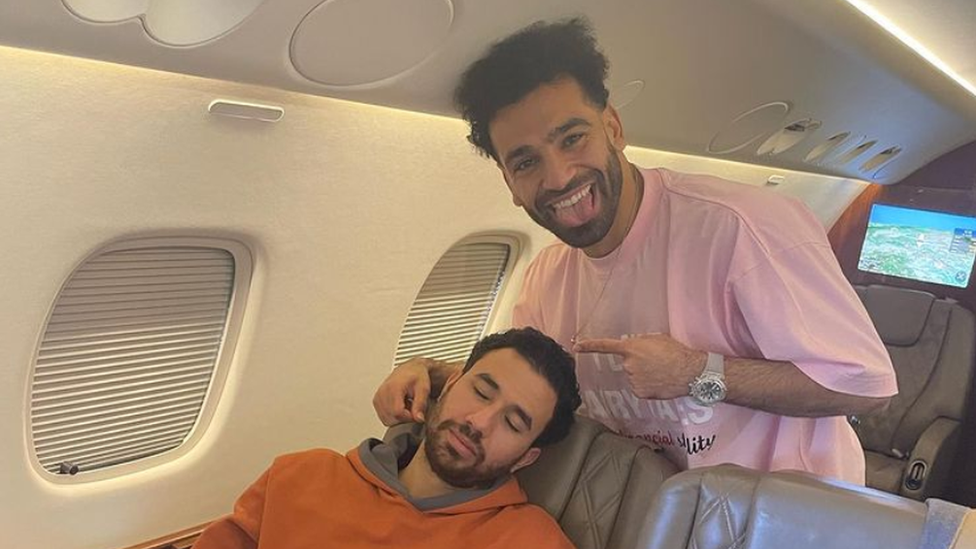 Mo Salah poses with Aston Villa midfielder and Egyptian teammate Trézéguet, who's asleep on the plane