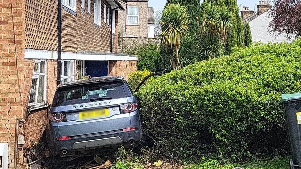 The car in the front of the house where it crashed into