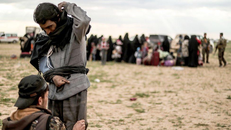 A man suspected of being an Islamic State (IS) group fighter is searched by a member of the Kurdish-led Syrian Democratic Forces (SDF) after leaving the IS group's last holdout of Baghouz, in Syria's northern Deir Ezzor province on February 27, 2019