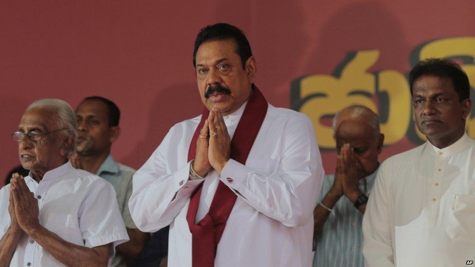 Former Sri Lankan president and parliamentary candidate Mahinda Rajapaksa (centre) prays along with this supporters during an election campaign in Colombo, Sri Lanka, Monday, 3 August 2015