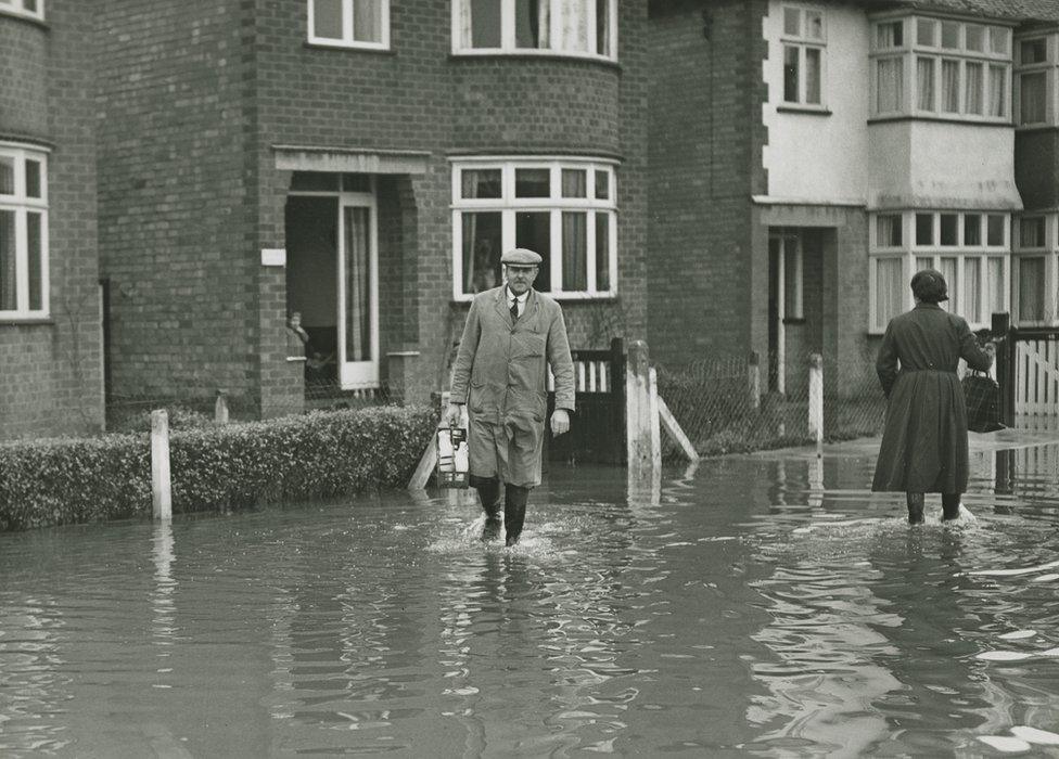 Milkman delivers during a flood