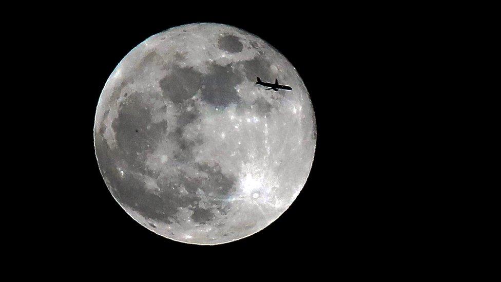 Plane framed by moon