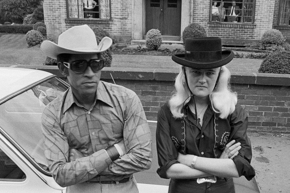 man and woman pose in cowboy hats