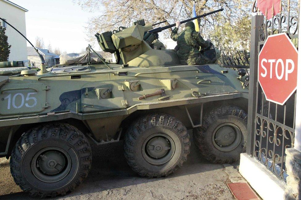 Soldiers - believed to be Russian troops - ram a gate at Belbek airbase, as Russian forces seize Ukrainian military bases in Crimea on 22 March 2014