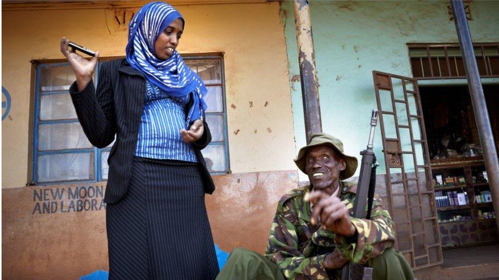 Fatuma Abdulkadir Adan with a soldier with a gun