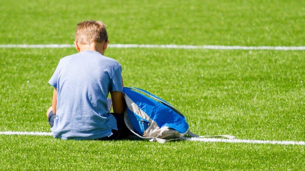 Boy siting on field