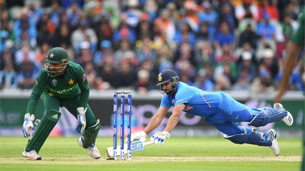 Rohit Sharma of India dives to make his ground as Sarfraz Ahmed looks on during the Group Stage match of the ICC Cricket World Cup 2019 between India and Pakistan at Old Trafford on June 16, 2019 in Manchester, England.