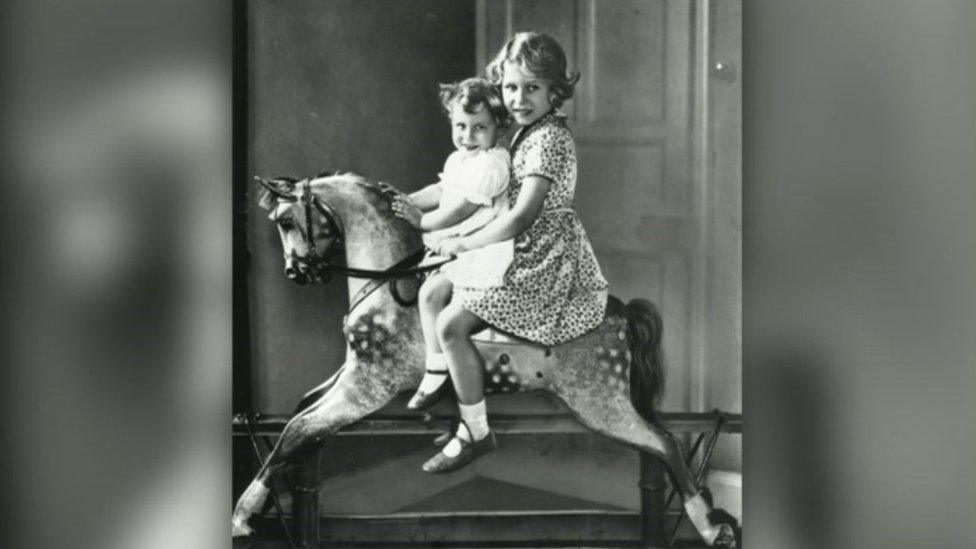 Princesses Elizabeth and Margaret on a rocking horse in the nursery in taken 1932.