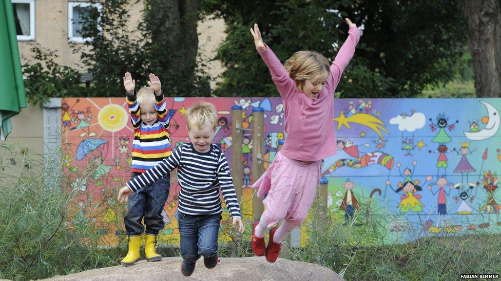 Children playing in front of a noise barrier in Germany