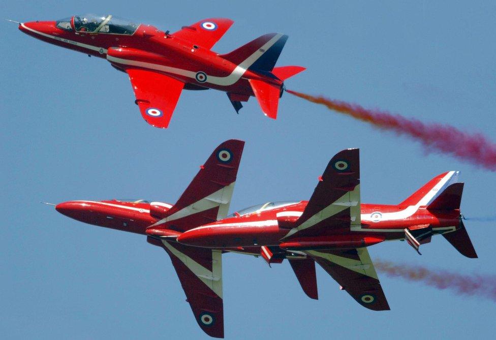 The Red Arrows display team demonstrate their close manoeuvres at the Farnborough air show, July 2004