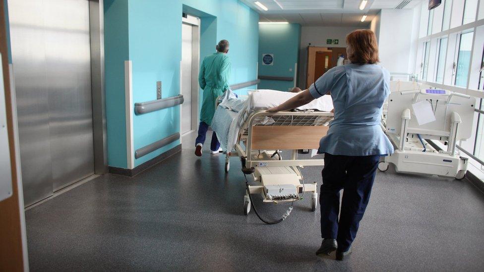 NHS staff with a patient on a trolley