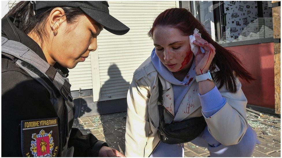 A police officer helps an injured woman