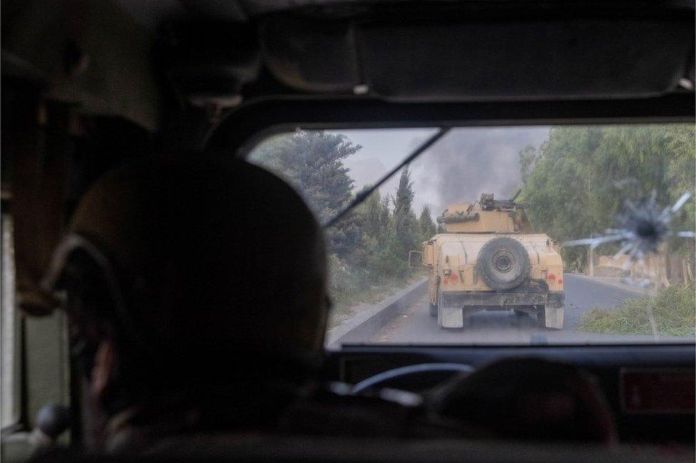 A member of Afghan Special Forces fires at Taliban after coming under heavy fire during the rescue mission of a police officer besieged at a check post, in Kandahar province, Afghanistan, July 13, 2021.