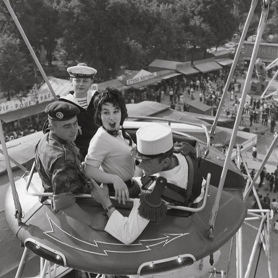 A woman on a fairground ride with three men