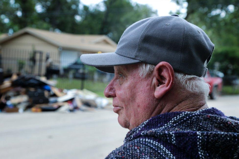 Melvin Lee Rogers surveys the damage outside the home he shares with his brother