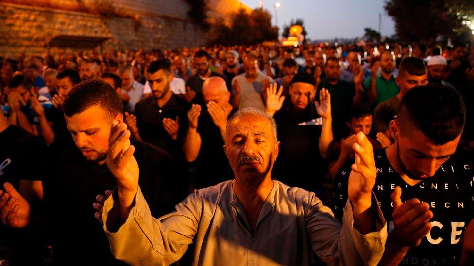 Palestinian Muslim worshippers pray outside Lions' Gate, a main entrance to the Al-Aqsa mosque compound in Jerusalem"s Old City, on July 22, 2017, in protest against new Israeli security measures implemented at the holy site following an attack that killed two Israeli policemen the previous week.