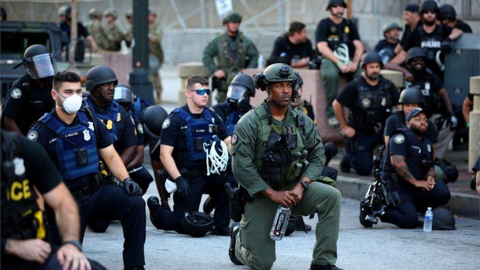 In Atlanta these police officers went down on one knee to remember George Floyd - a gesture which was made famous by former NFL player Colin Kaepernick as a protest against racial injustice and police brutality.